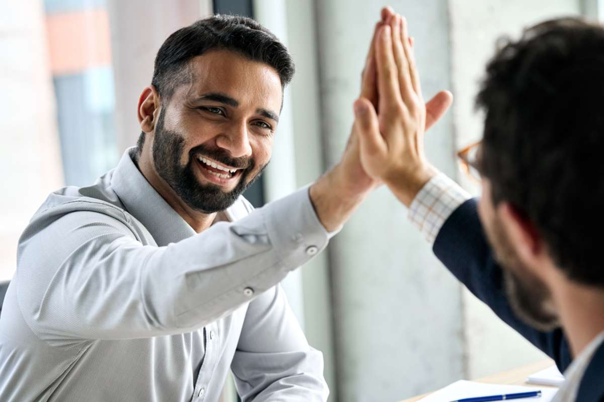 Indian happy smiling multiracial professional ceo businessman giving highfive to business partner