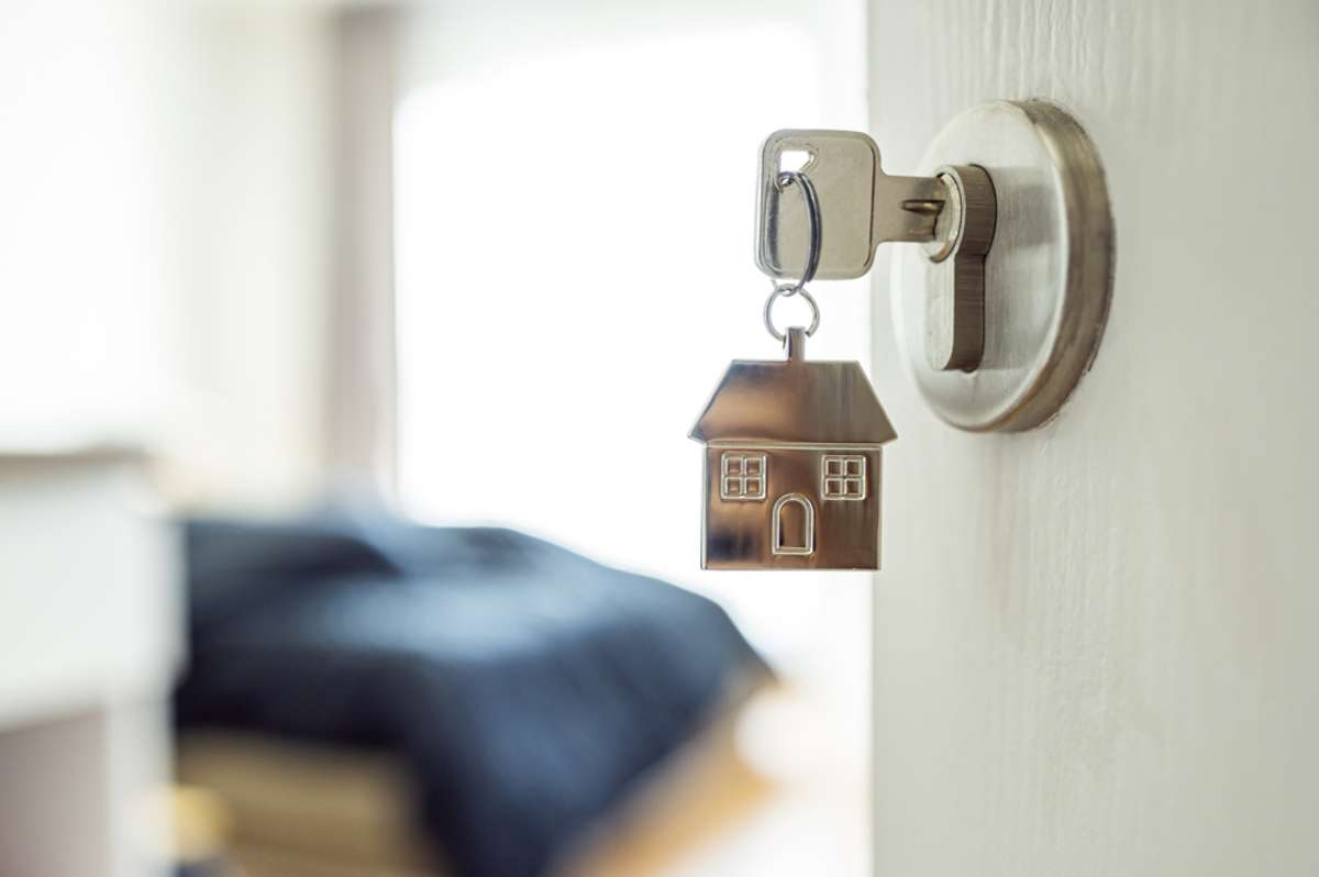 Open the door and door handle with a key and a keychain shaped house