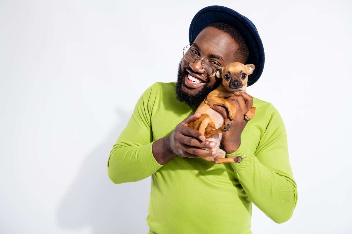 Portrait of cheerful guy hugging his toy terrier wearing eyeglasses eyewear isolated over white background (R) (S)