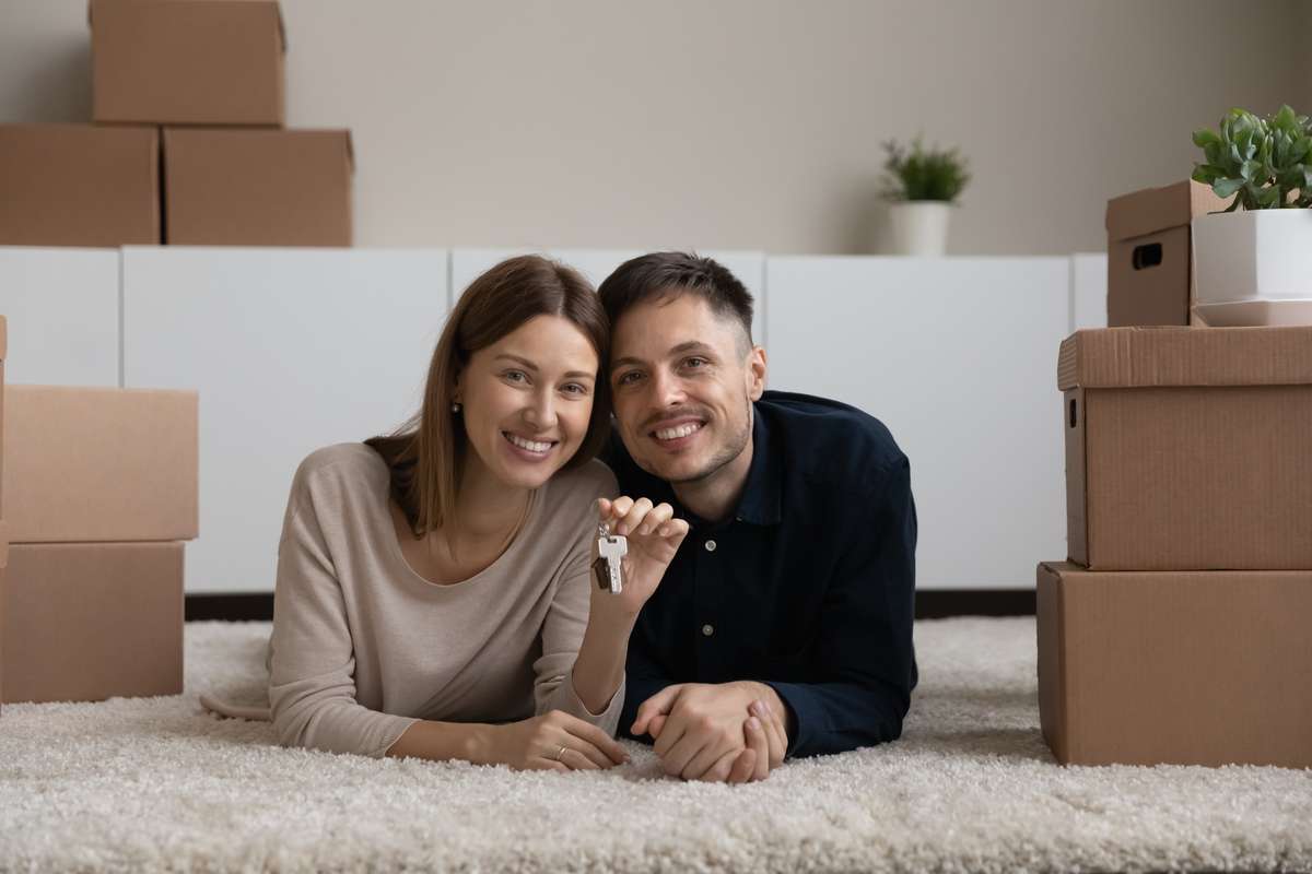 Portrait of happy couple showing key, excited by relocation (R) (S)
